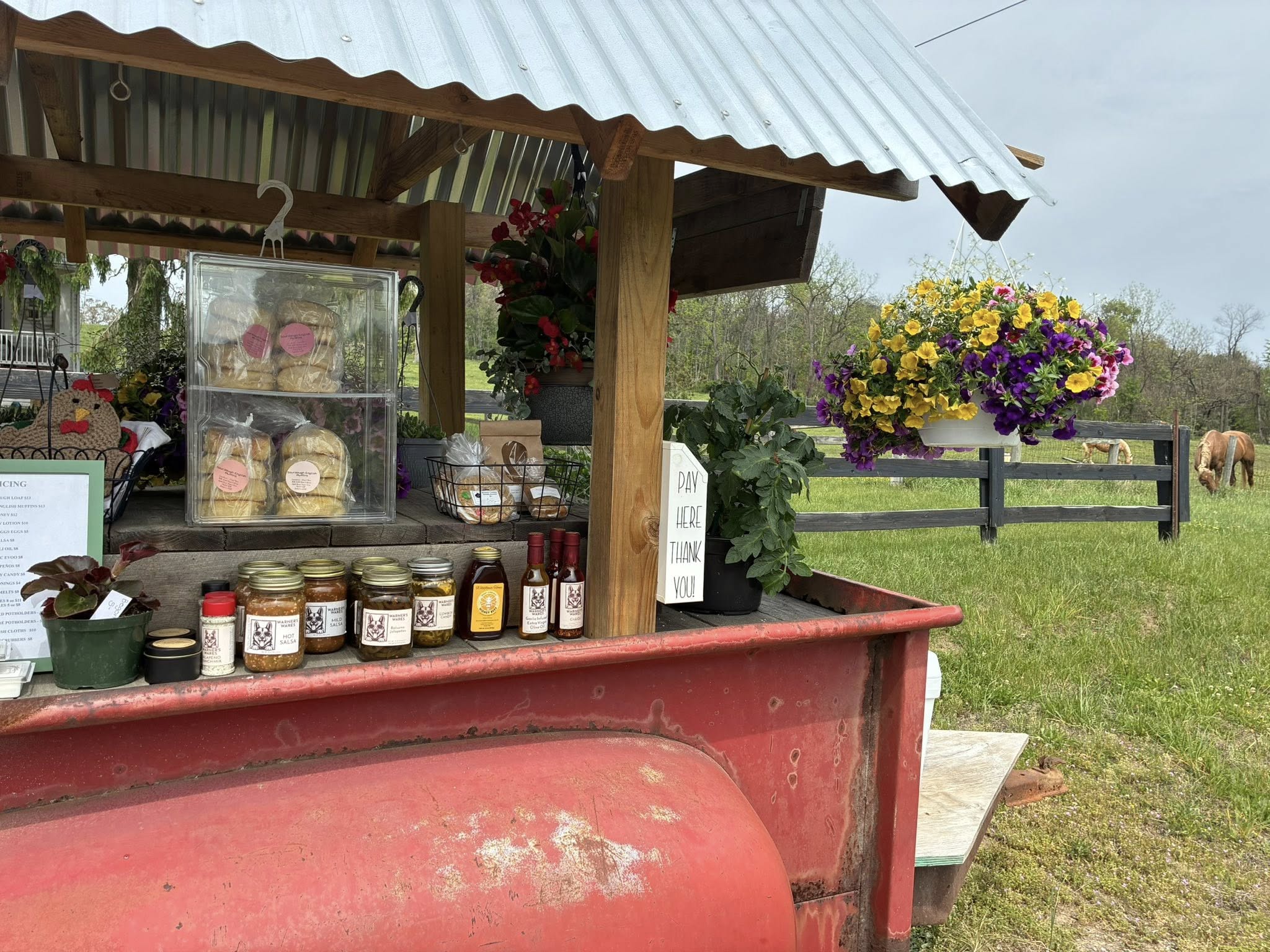 Market counter with breads, jars, flowers, and packaged goods